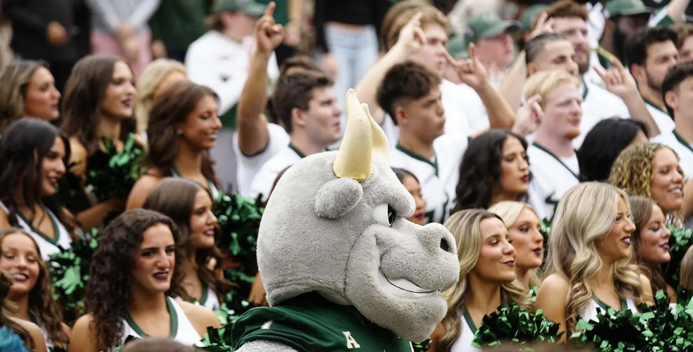 Fans in the crowd with mascot and cheerleaders in foreground